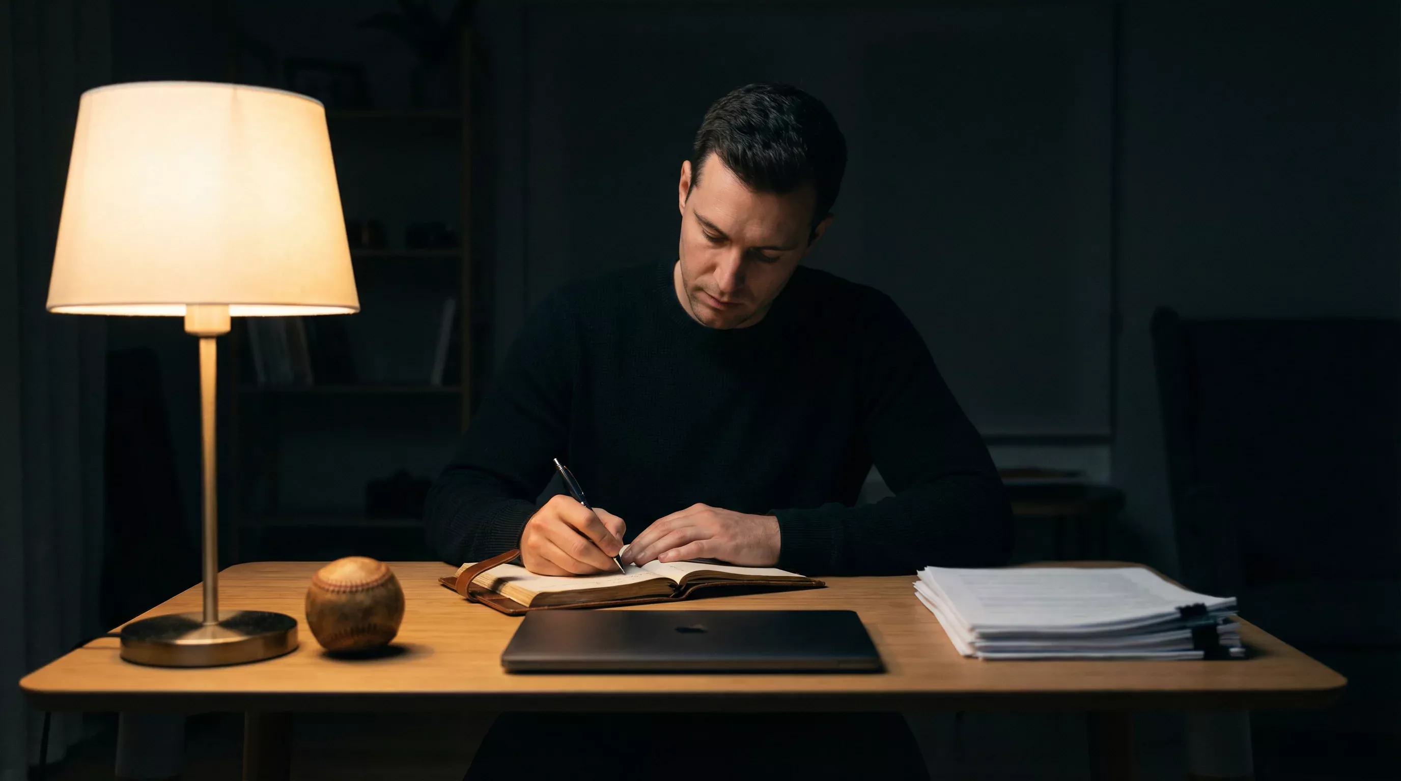 Homme concentré analysant calmement des données de baseball sur un bureau épuré